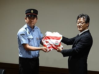 九州ラグビー協会事務局の藤田克道様から、ＪＲ熊本駅長の出口拡様にジャージの贈呈
